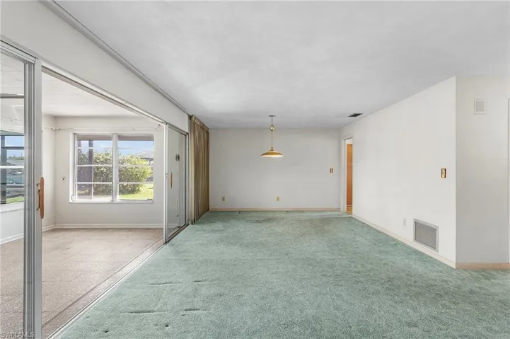 Living/Dining room with door to the kitchen and flows from the foyer and into the Florida Room with pocket sliders