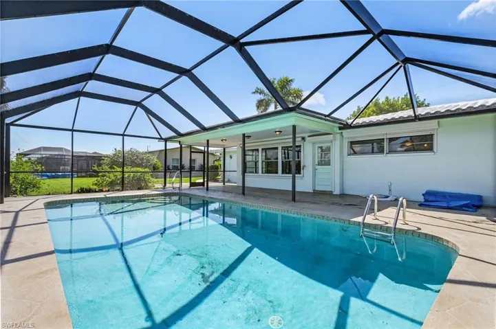 View of heated  pool with screen enclosure, and a lots of patio areaWindows from Primary Bedroom, door from Florida room and new windows in Florida room all have rool down hurricane shutters