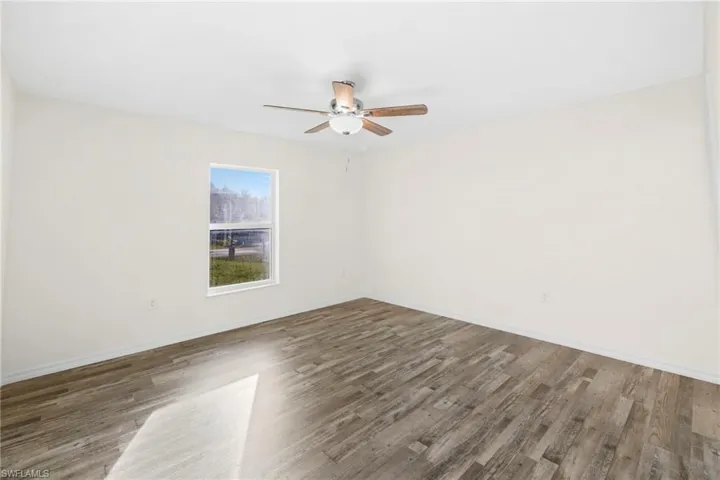 Spare room with wood finished floors and ceiling fan