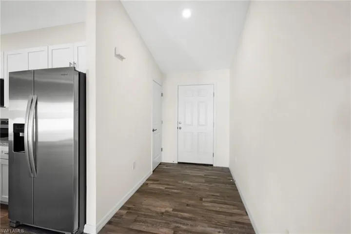 Hallway featuring baseboards and dark wood-style flooring