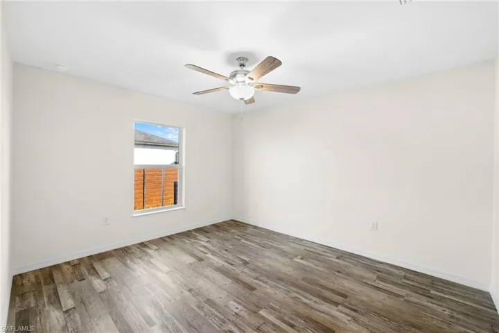 Empty room with wood finished floors and a ceiling fan