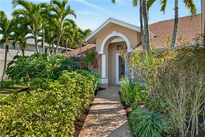Property entrance with a shingled roof and stucco siding