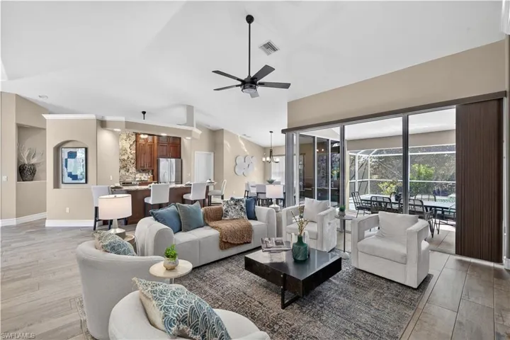 Living room with healthy amount of natural light, light wood-style flooring, ceiling fan, and a sunroom