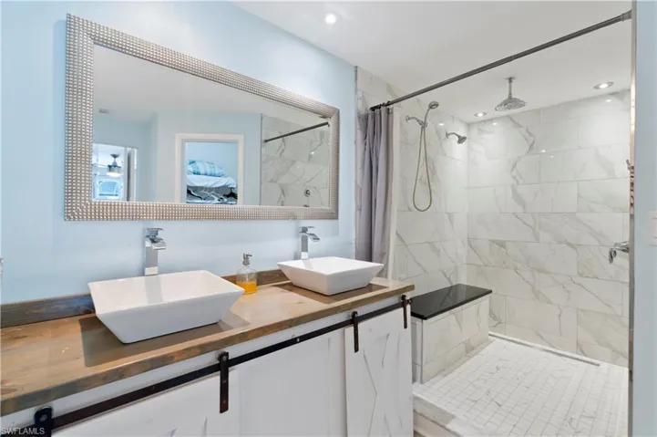 Full bathroom with a marble finish shower and double vanity