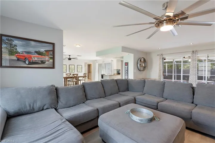 Living area with ceiling fan and light wood-style flooring