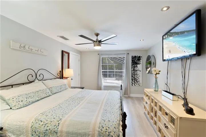 Bedroom featuring light wood-style flooring, ceiling fan, and recessed lighting