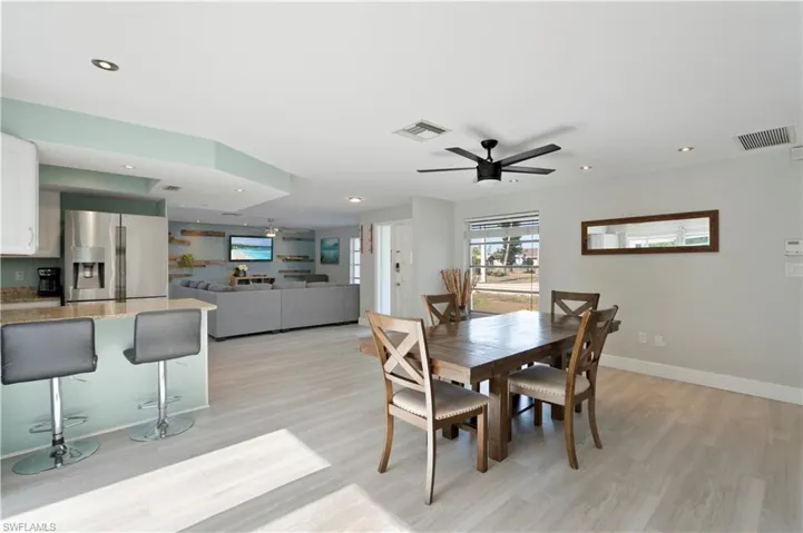 Dining area with light wood-style floors, ceiling fan, and recessed lighting