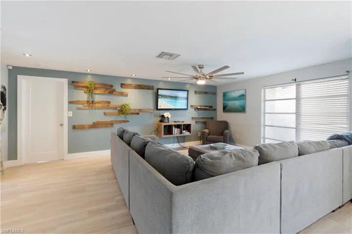 Living room with a ceiling fan, light wood-type flooring, and recessed lighting
