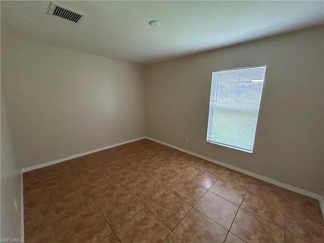 Spare room with baseboards and tile patterned flooring