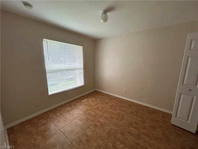 Unfurnished room with tile patterned floors and a smoke detector