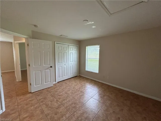 Unfurnished bedroom featuring light tile patterned flooring and a closet