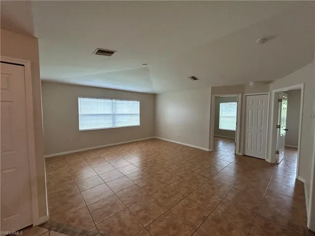 Tiled spare room with healthy amount of natural light and lofted ceiling
