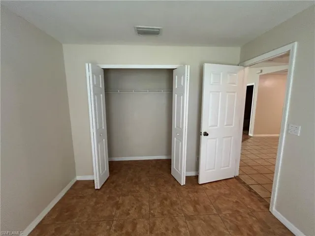 Unfurnished bedroom with tile patterned floors and a closet