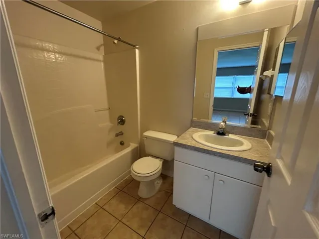 Bathroom featuring tile patterned flooring, vanity, and tub / shower combination