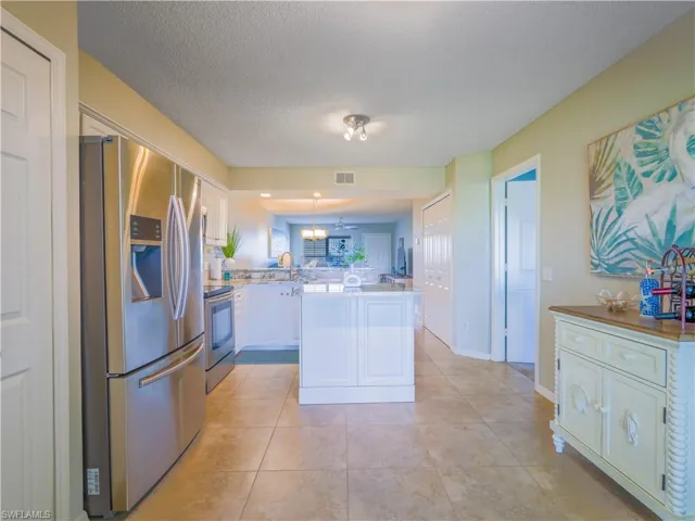 Kitchen featuring stainless steel appliances, white cabinetry, and granite counters