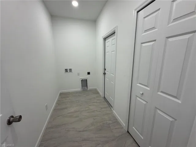 Washroom with hookup for an electric dryer, light marble finish floors, hookup for a washing machine, and recessed lighting