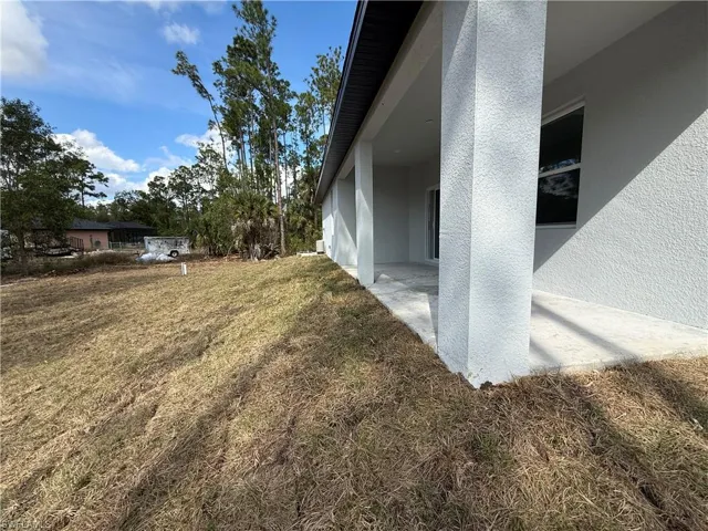 View of home's exterior featuring a patio area, a yard, and stucco siding