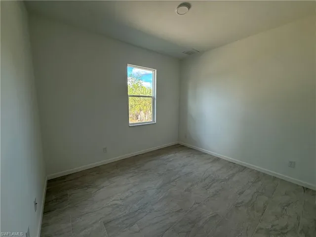 Spare room featuring baseboards