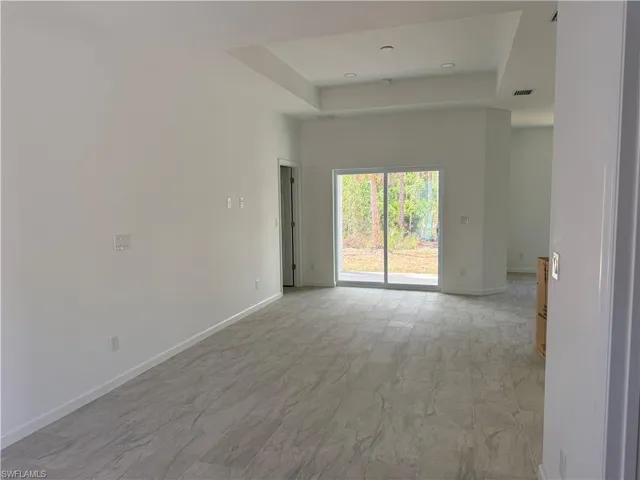 Empty room with a tray ceiling and baseboards