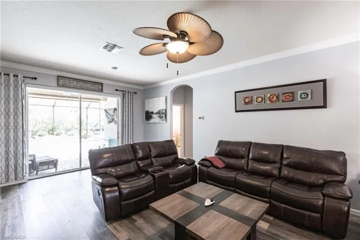 Living room featuring crown molding, hardwood / wood-style flooring, and a textured ceiling