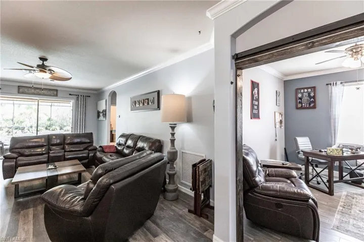 Living room with ornamental molding, ceiling fan, and hardwood / wood-style floors