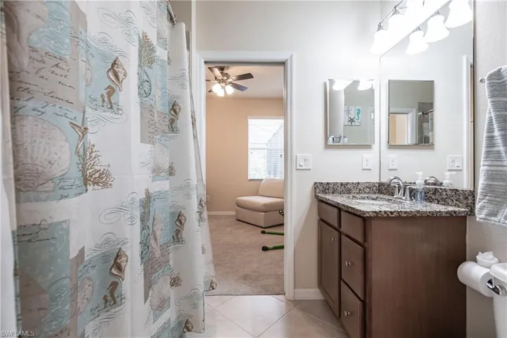 Bathroom featuring ceiling fan, tile flooring, and vanity
