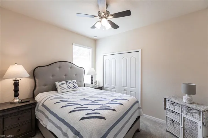 Bedroom featuring a closet, ceiling fan, and carpet floors
