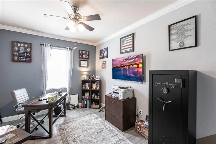 Office area with crown molding, ceiling fan, and hardwood / wood-style floors