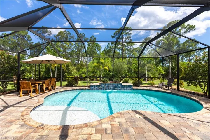View of pool featuring a patio area, pool water feature, and a lanai