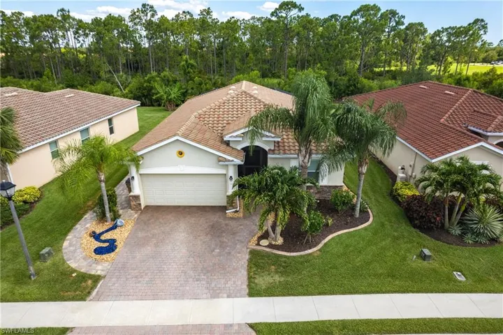 View of front of property featuring a garage and a front lawn