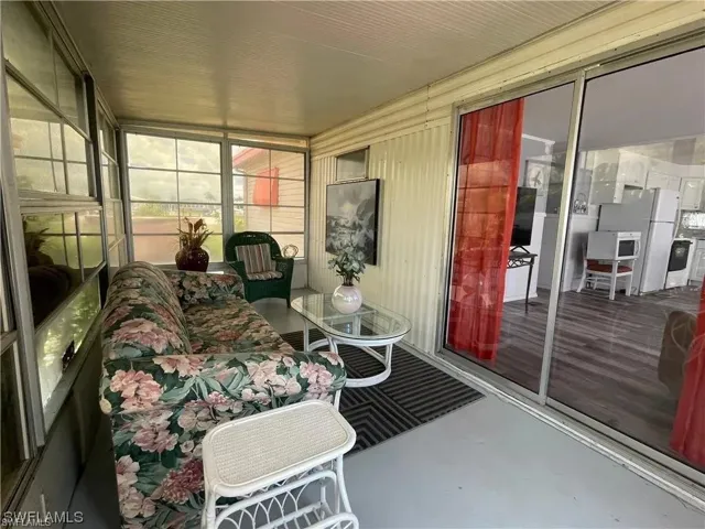 Enclosed patio featuring multiple windows, a grey floor finish, and sliding glass doors