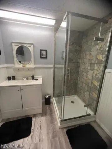 Shower enclosure featuring glass panels and stone-look tile surround
