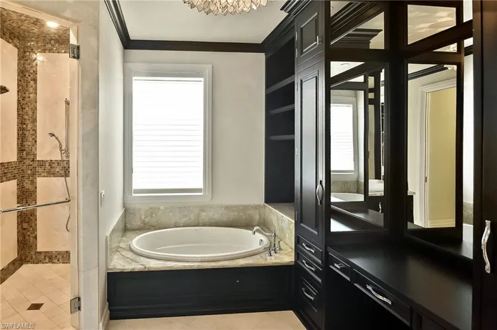 Bathroom featuring tile patterned floors, plenty of natural light, ornamental molding, and independent shower and bath
