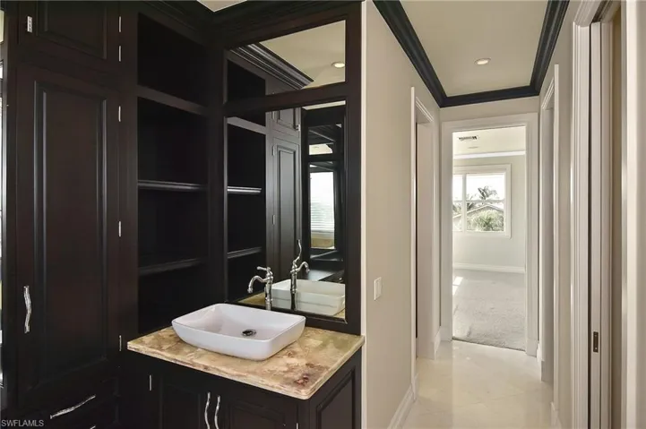 Bathroom with tile patterned flooring, ornamental molding, and vanity