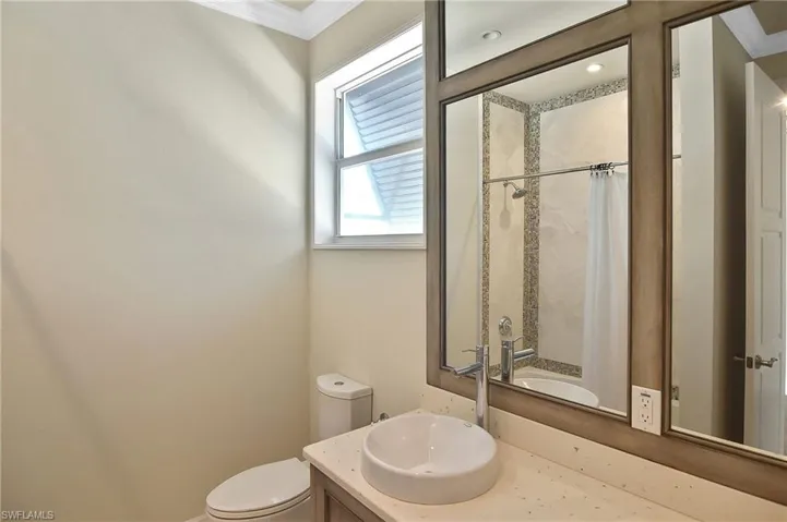 Bathroom featuring vanity, crown molding, and toilet