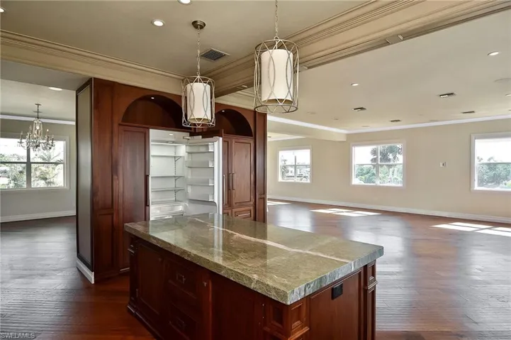 Kitchen with crown molding, a kitchen island, and dark hardwood / wood-style floors
