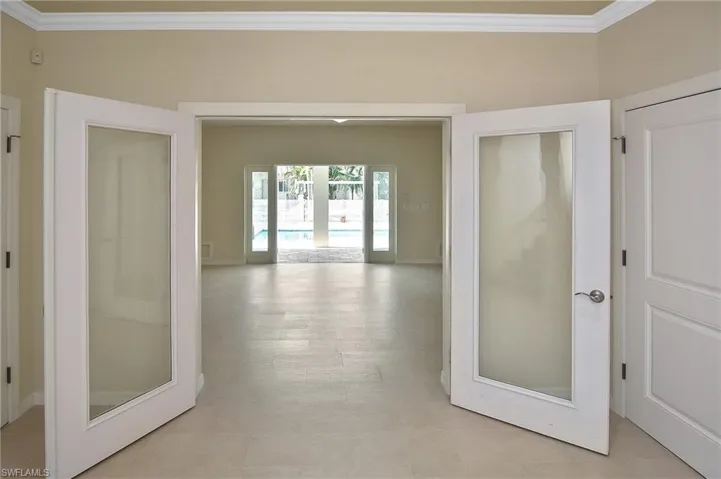 Hall with crown molding and french doors