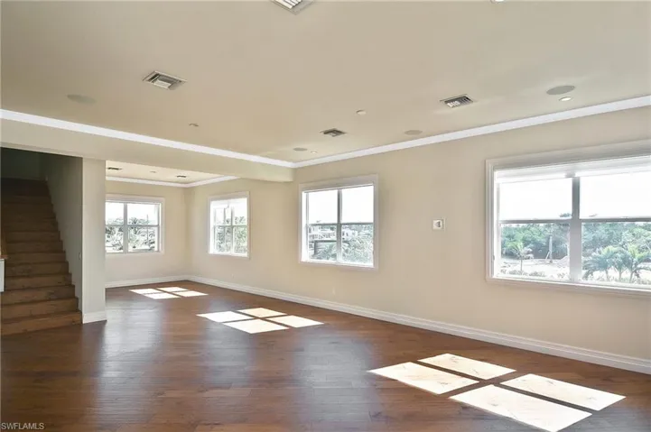 Spare room featuring dark hardwood / wood-style flooring and ornamental molding