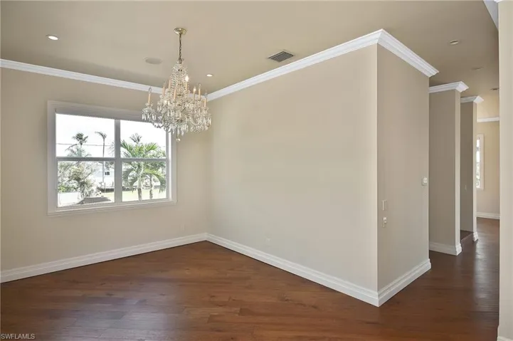 Empty room featuring crown molding and dark hardwood / wood-style flooring