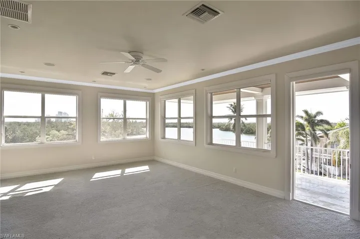 Empty room with ceiling fan, ornamental molding, and carpet floors