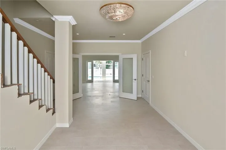 Foyer entrance featuring crown molding and french doors