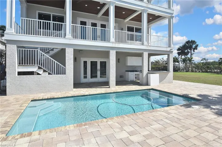 View of swimming pool with an outdoor kitchen and a patio