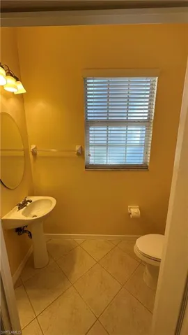 Half bathroom with toilet and light tile patterned floors