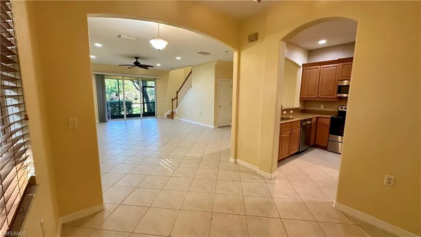 Kitchen with ceiling fan, appliances with stainless steel finishes, light countertops, light tile patterned floors, and hanging light fixtures