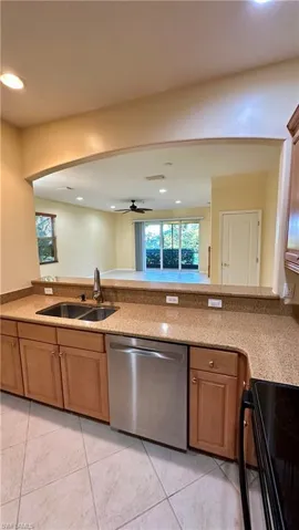 Kitchen featuring black electric range oven, stainless steel dishwasher, recessed lighting, light stone countertops, and a ceiling fan
