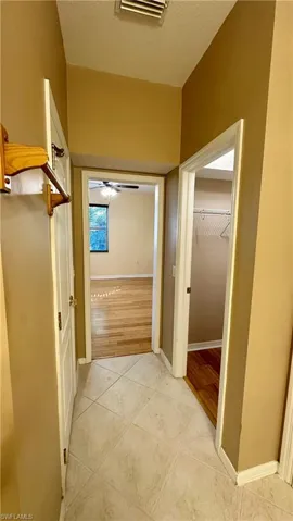 Hall with light tile patterned floors and a textured ceiling