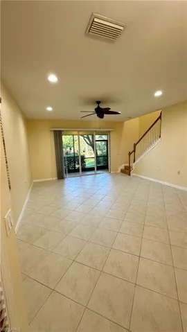 Empty room with recessed lighting, stairs, ceiling fan, and light tile patterned floors