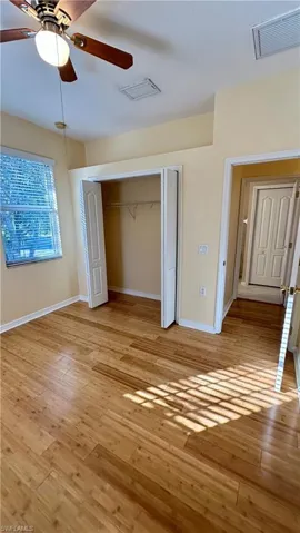 Unfurnished bedroom featuring a closet, light wood-type flooring, and a ceiling fan