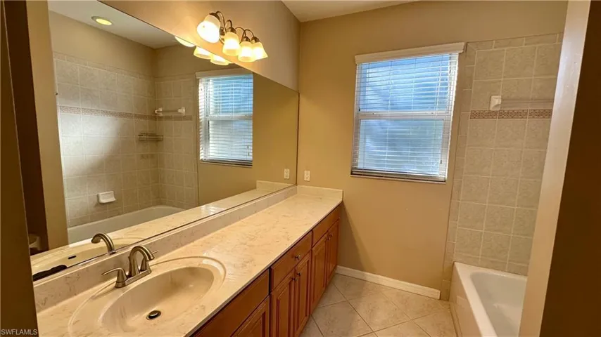 Full bath with vanity, bathing tub / shower combination, and light tile patterned floors