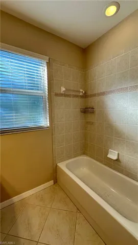 Bathroom with a textured ceiling and light tile patterned flooring